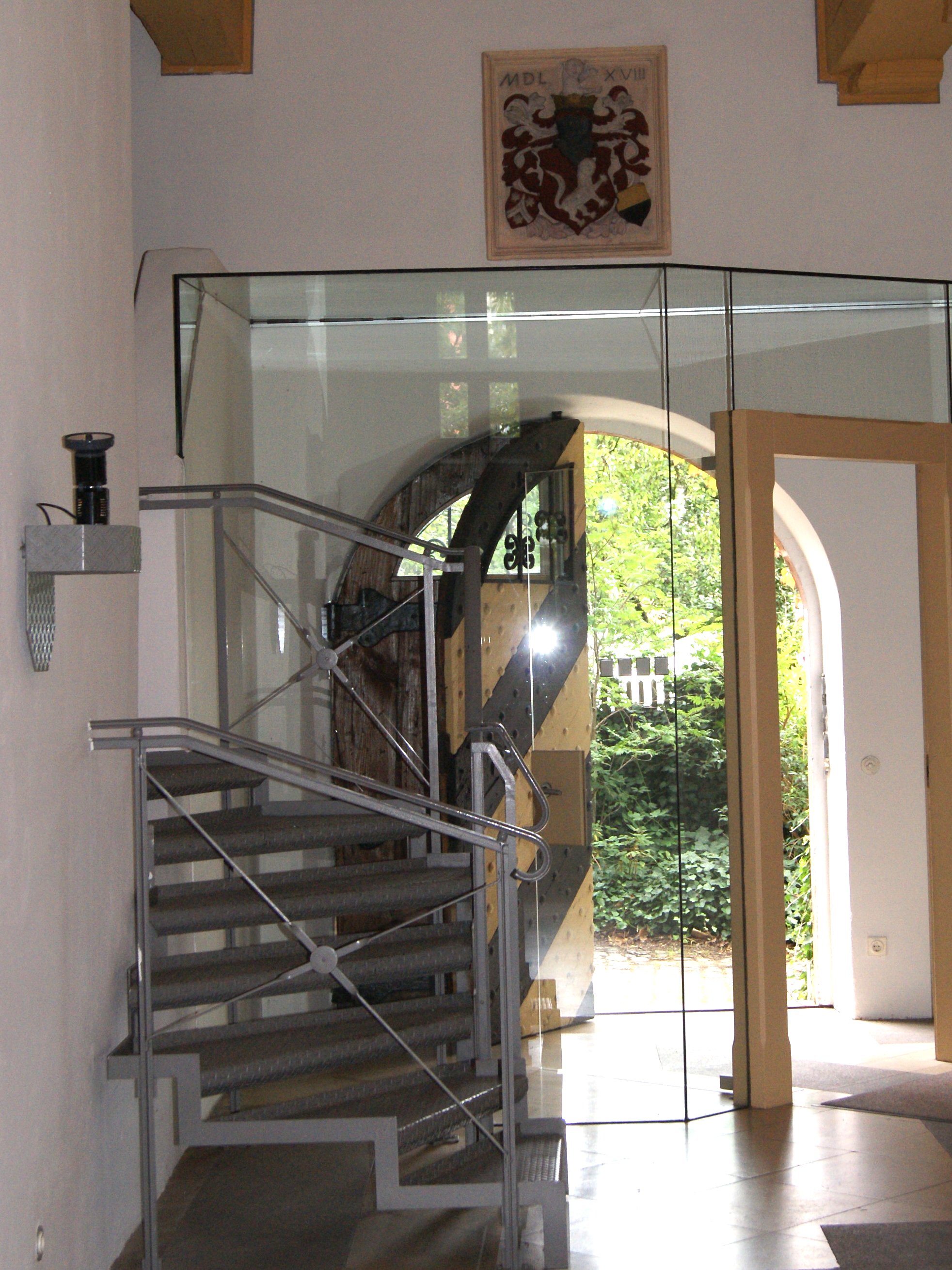 Entrance area château Pfinzing with glass door and coat of arms