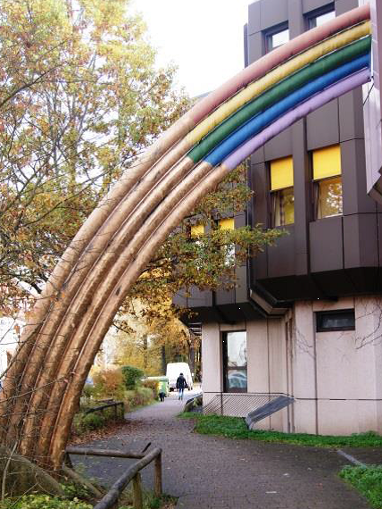 Das Bild zeigt einen stilisierten, das Treppenhaus durchdringenden Regenbogen